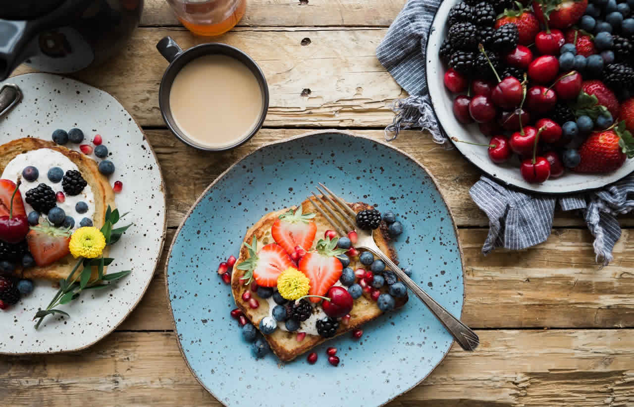 Colorful breakfast and fresh fruit arranged on a wooden table